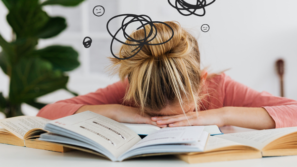 Woman resting her head on a surface looking exhausted despite sleeping, illustrating hormone-related fatigue caused by cortisol, adrenal, and testosterone imbalances
