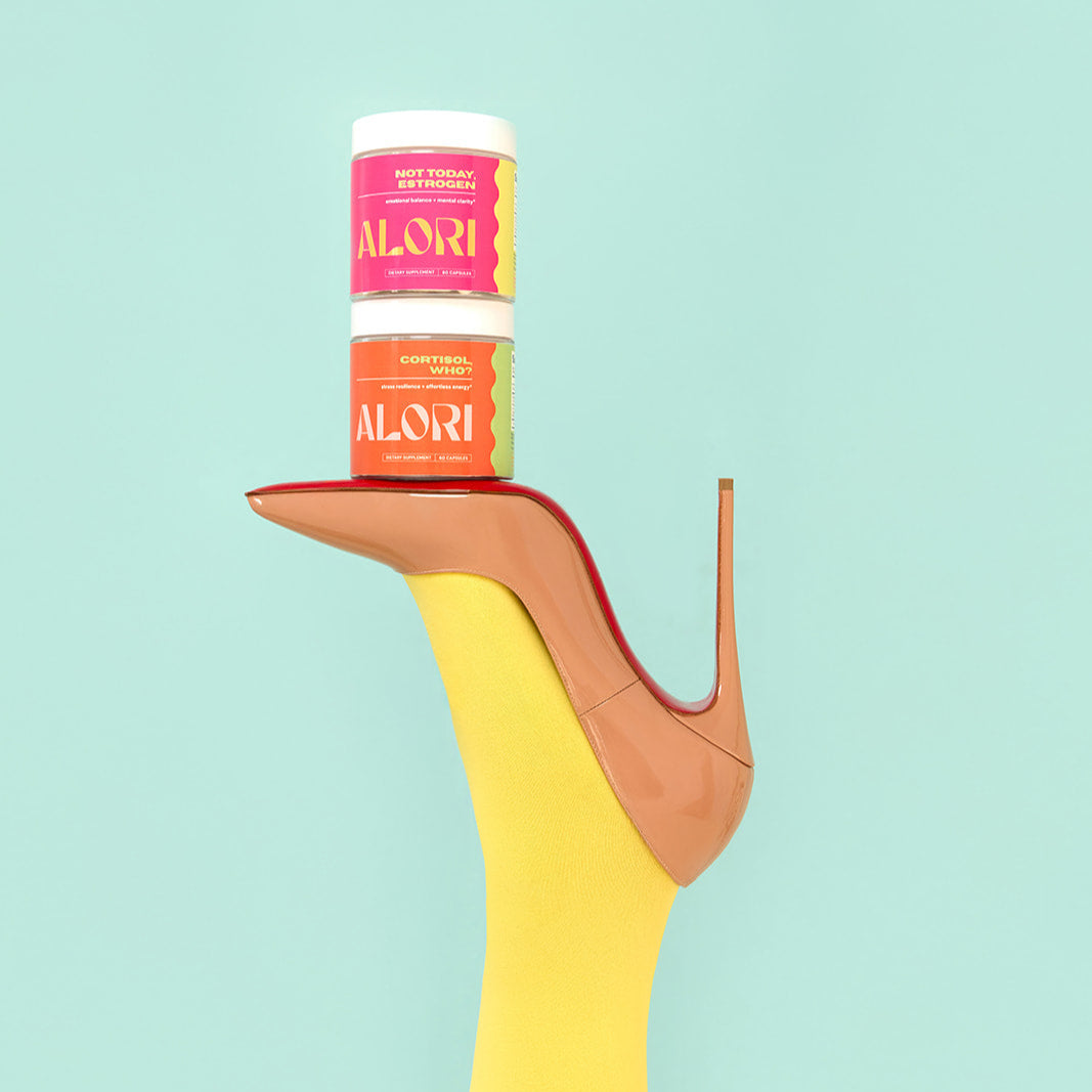 Two 'ALORI' supplement products on a high-heeled shoe against a light blue background